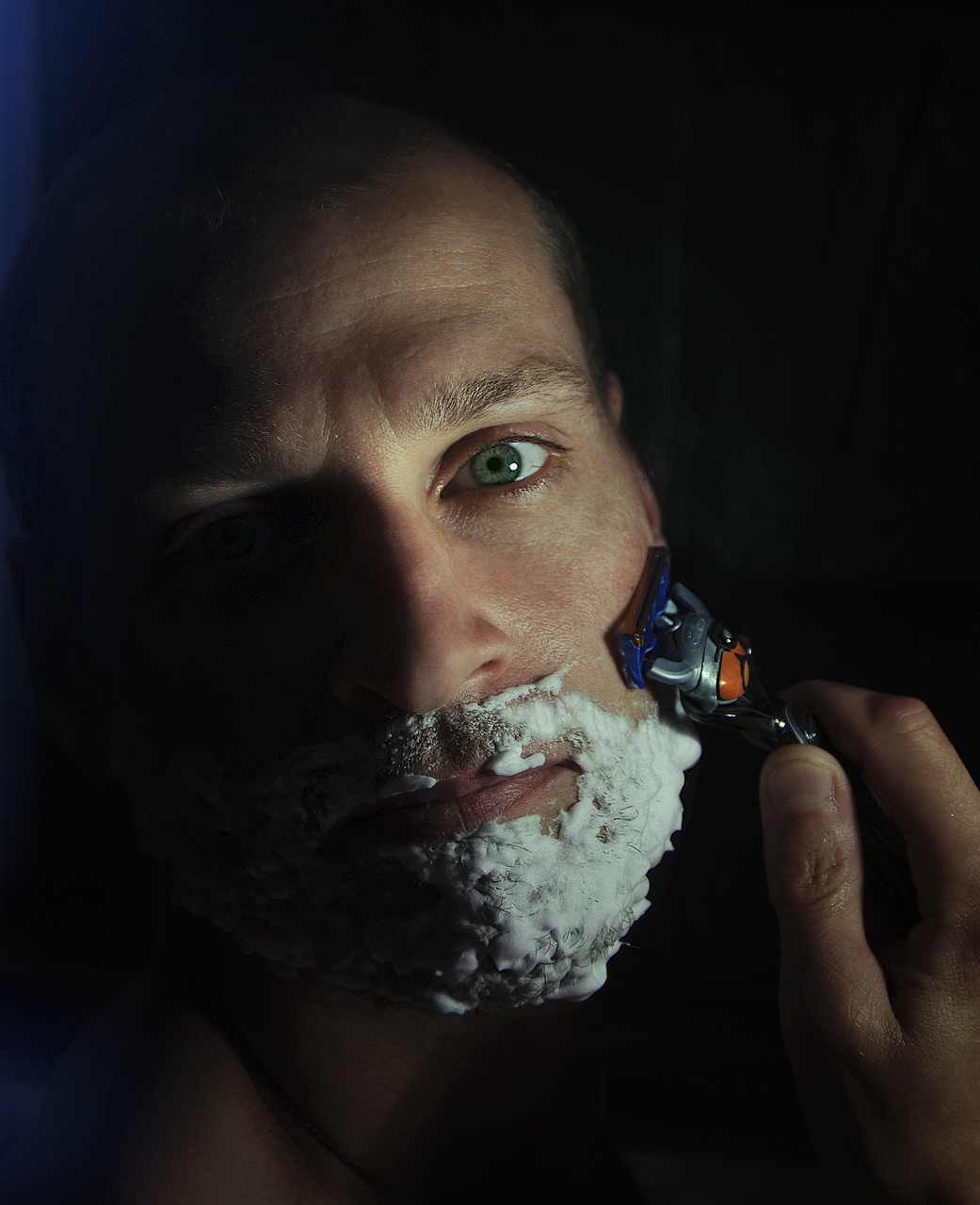 man with shaving cream and shaving his beard with a Gillette Safety Razor